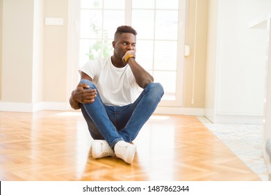 Handsome african american man sitting on the floor at home thinking looking tired and bored with depression problems with crossed arms.