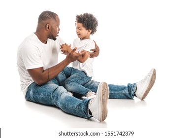 handsome african american man talking to adorable son on white background
