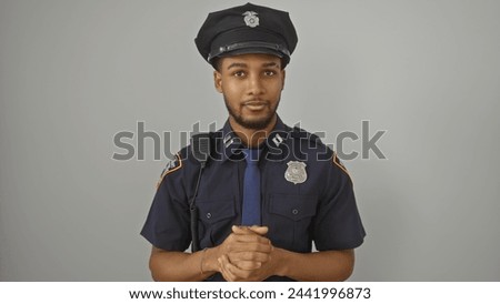 Handsome african american police officer with clasped hands against a white background.