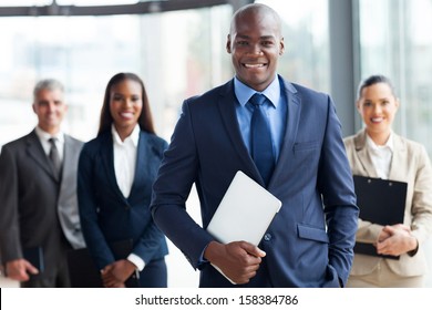 handsome african businessman with group of businesspeople on background