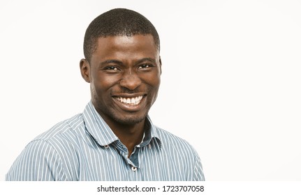 Handsome African Guy With White-toothed Smile Looking At Camera, Dark-skinned Well-dressed Young Man Cut Out On White Background. Concept Of Dental Care. Copy Space At Right. Toned Image.