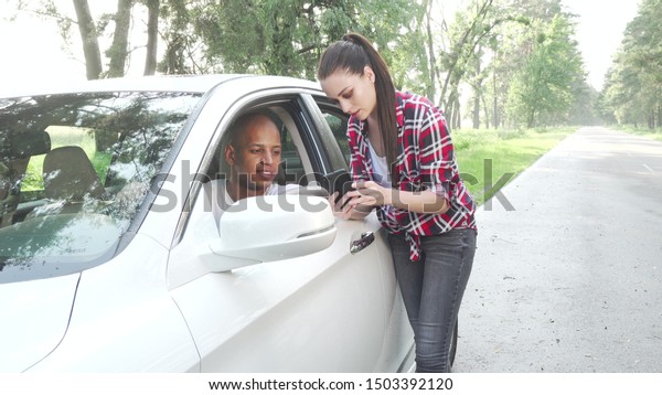 Handsome African man asking woman for direction while\
travelling by car