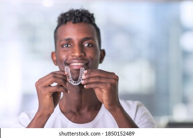 Handsome African Young Man Is Holding An Invisaligner, image with copyspace