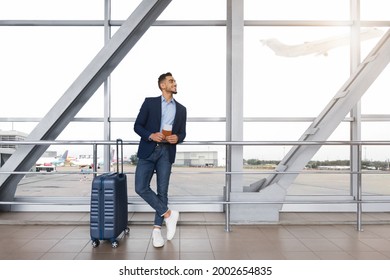 Handsome Arab Man Holding Passports And Tickets Standing With Suitcase Near Window In Airport Terminal, Young Middle Eastern Entrepreneur Waiting For Boarding, Enjoying Business Trip, Copy Space