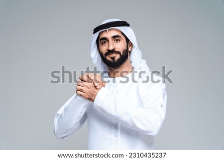 Handsome arab middle-eastern man with traditional kandora in studio - Arabic muslim adult male portrait wearing emirate clothing in Dubai, United Arab Emirates