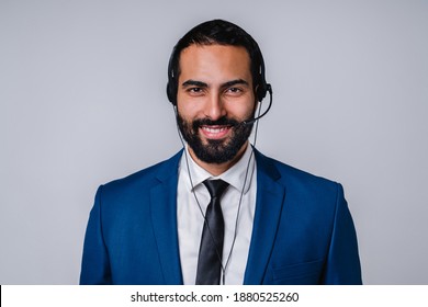 Handsome Arabic call center worker in formal suit isolated over grey background
