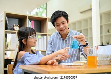 Handsome Asian Male Teacher Teaching And Showing A Science Experiment To A Young Student At School Lab.