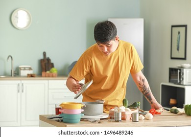 Handsome Asian Man Cooking In Kitchen