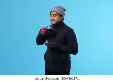 Handsome Asian Man Enjoying A Cup Of Hot Tea In Winter Clothes