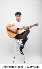 Handsome Asian Man Play Guitar On Grey / White Background