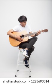 Handsome Asian Man Play Guitar On Grey / White Background