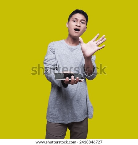 Handsome Asian Man Poses with Cellphone, Index Finger Touching Screen to Release Application