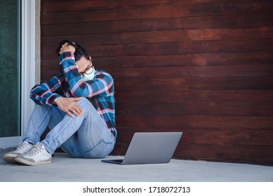Handsome Asian man working as a freelance mask sits sad and stressed from his unemployment at home on a laptop computer. Unemployment concept fails during covid strain Omicron, Delta - Shutterstock ID 1718072713