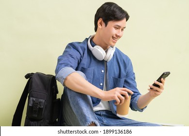 Handsome Asian Student Boy Sitting Using Smart Phone
