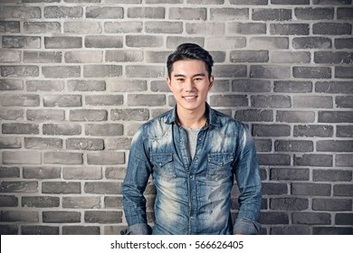 Handsome Asian Young Man Smile Against The Gray Brick Wall