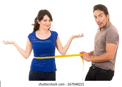 handsome astonished man holding measuring tape around thin fit young girl's waist concept of dieting fitness weightloss  isolated on white