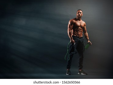 Handsome Athletic Men Holding Protein Drink Bottle And Resistance Bands 