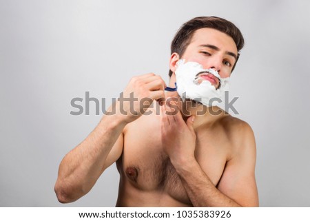 Handsome and attractive man is in the process af shaving his beard. He doesn't regret about that. This man use really good blade. Advertizement concept. Cut view. Isolated on white background