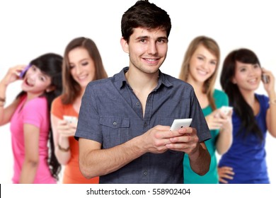handsome attractive young man using mobile phone. four diverse ethnicity woman at the background