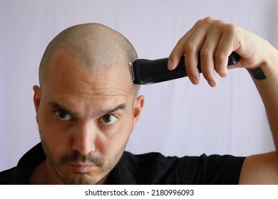 Handsome Average Bald Man Shaving With An Electric Razor