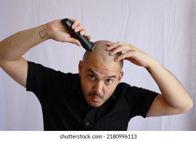 Handsome Average Bald Man Shaving With An Electric Razor