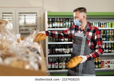 Handsome Baker In Uniform Puts Fresh Pastry Bread On Shelves In Supermarket, Grocery Store Worker Puts Product On Shelf With Bread, Clerk Working In Store, Alcohol Department Background, Copy Space