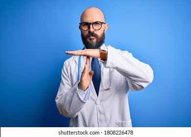 Handsome Bald Doctor Man With Beard Wearing Glasses And Stethoscope Over Blue Background Doing Time Out Gesture With Hands, Frustrated And Serious Face