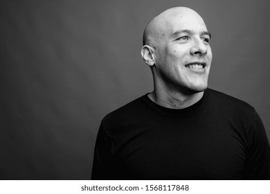 Handsome Bald Man Against Gray Background In Black And White