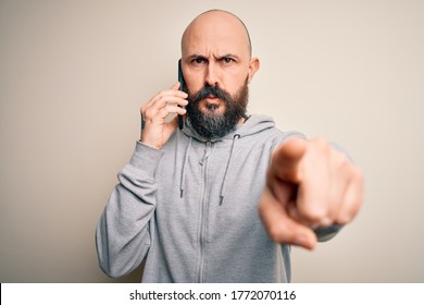 Handsome Bald Man With Beard Having Conversation Talking On The Smartphone Pointing With Finger To The Camera And To You, Hand Sign, Positive And Confident Gesture From The Front