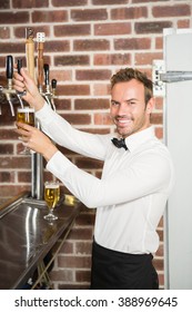 Handsome Bar Tender Pouring A Pint In A Pub