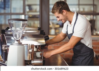 Handsome barista making a cup of coffee at the coffee shop