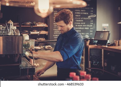 Handsome barista preparing cup of coffee for customer in coffee shop. - Powered by Shutterstock