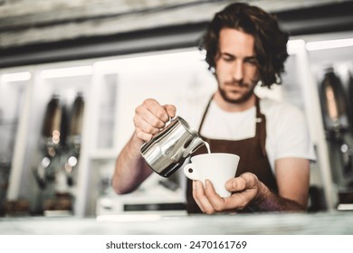 Handsome barista working in coffee shop, preparing coffee. University student working part-time in cafe. - Powered by Shutterstock