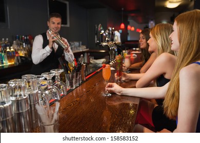 Handsome Bartender Making Cocktails For Attractive Women In A Classy Bar