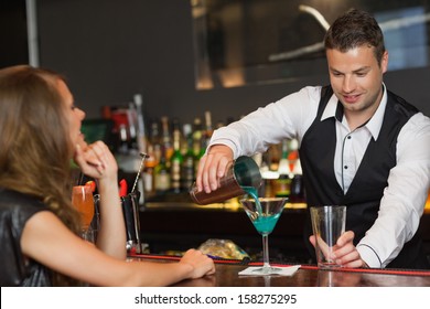 Handsome Bartender Serving Cocktail To Attractive Woman In A Classy Bar