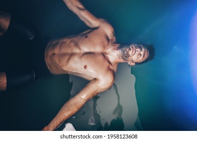 Handsome Beard Man Floating In Tank Filled With Dense Salt Water Used In Meditation, Therapy, And Alternative Medicine. 