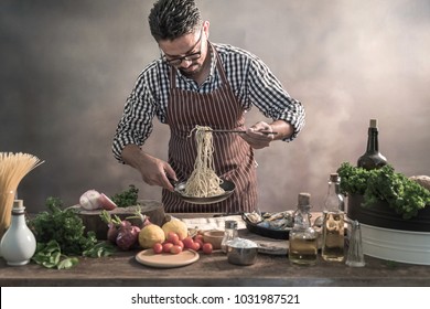 Handsome bearded cheef cook prepairing spaghetti on a kitchen, Chef cooks meal - Powered by Shutterstock