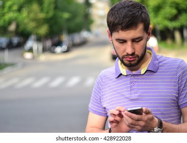 Handsome bearded guy using smart phone outdoors 