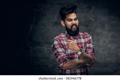 A handsome bearded Indian male dressed in a fleece shirt over grey vignette background.