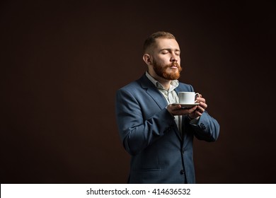 Handsome Bearded Man Enjoying Smell Of Coffee.