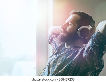 handsome bearded man  in headphones listening to music - Shutterstock ID 658487236