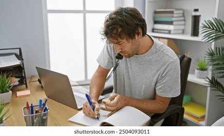 Handsome bearded man multitasking in a modern office, eating while writing notes and talking on the phone. - Powered by Shutterstock