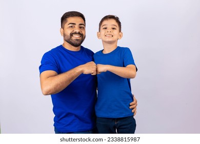 Handsome bearded man standing next to his son smiling at camera