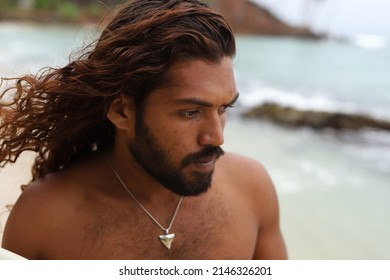 Handsome Bearded Sexy  Man With Long Dark Hair. Close Up Portrait Of Handsome Man With Long Dark Wavy Hair And Beard.Outside.Ocean Background.Living In Tropic