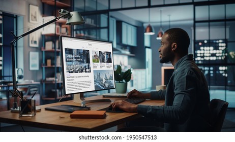 Handsome Black African American Specialist Working On Desktop Computer In Creative Home Living Room. Freelance Male Is Reading News For Financial Market Analysis And Report For Clients And Employer.