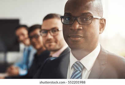 Handsome Black Business Man With Three Employees And Back To Large Bright Office Window With Light Flare