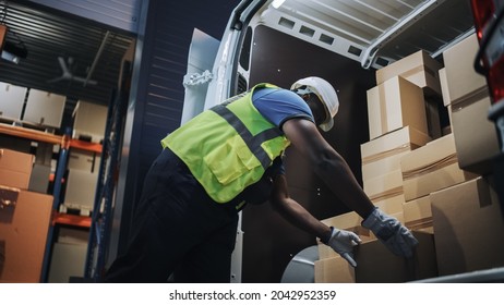 Handsome Black Male Retail Warehouse Worker  Loads Cardboard Boxes In  Delivery Truck. Logistics Retail Center, Delivering E-Commerce Online Orders, Food And Medicine Supply. Low Angle Evening Shot