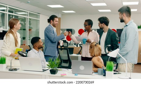 A Handsome Black Man With A Briefcase Walks Into A Morning Office Meeting And Is Shaking Hands With Everyone