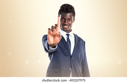 Handsome black man counting one over ocher background