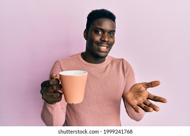 Handsome Black Man Drinking A Cup Of Coffee Celebrating Achievement With Happy Smile And Winner Expression With Raised Hand 